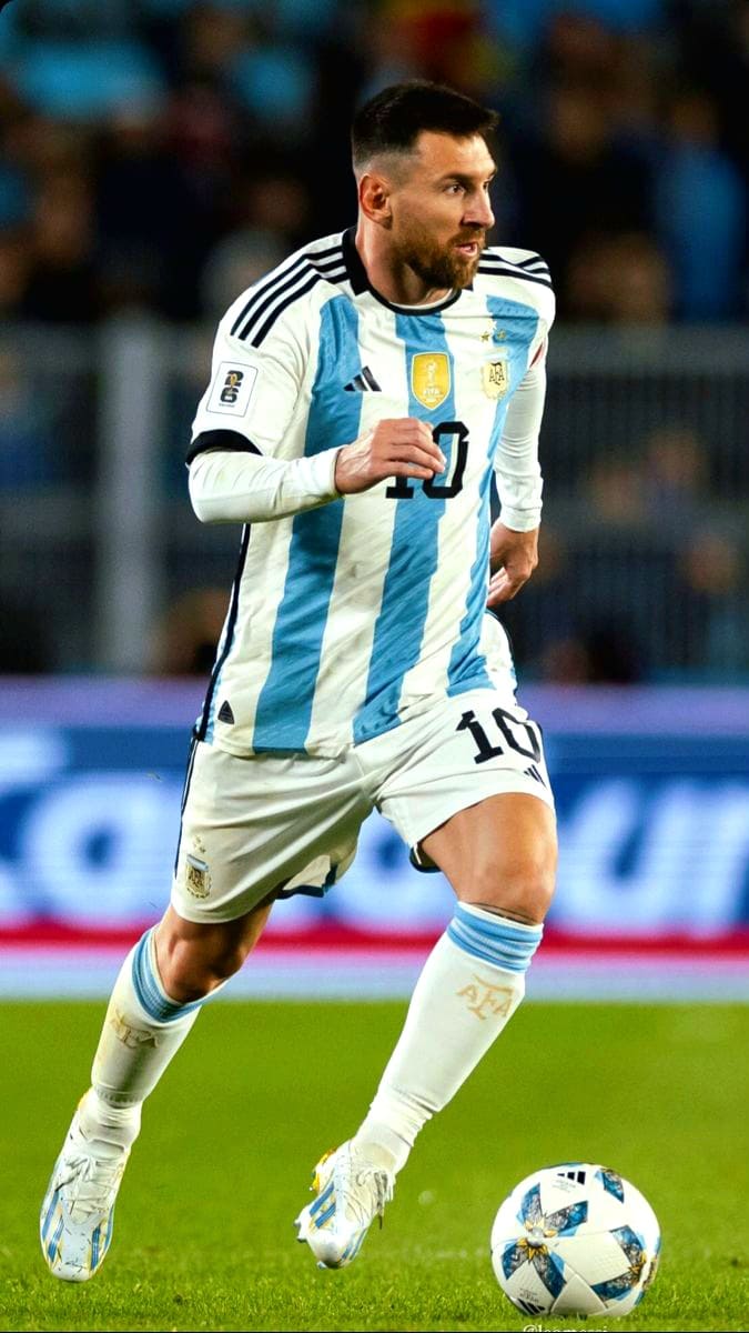A male soccer player in an Argentina national team jersey, number 10, runs on the field dribbling a soccer ball during a match, as fans watch from the stands—an exciting moment you can catch live with Bulgaria IPTV.